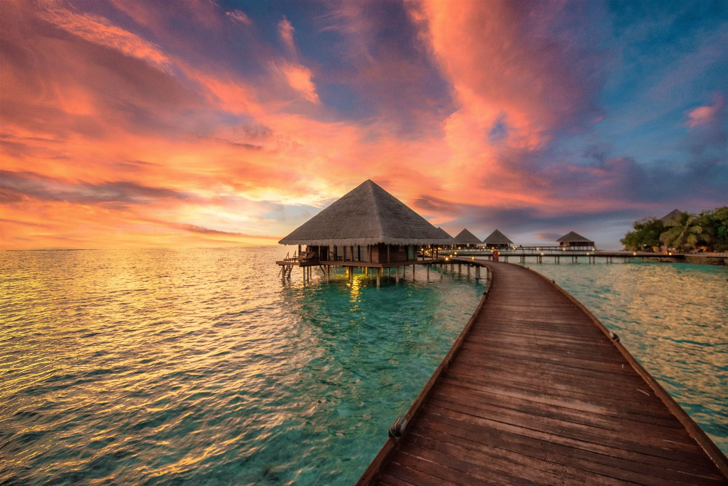 Boardwalk to overwater villas at sunset